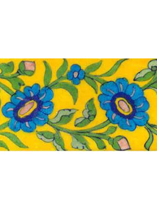 turquoise flower with green leaves on yellow tile