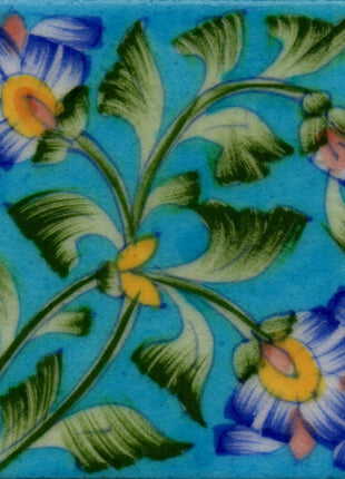 Two Blue flowers with green leaves on turquoise tile